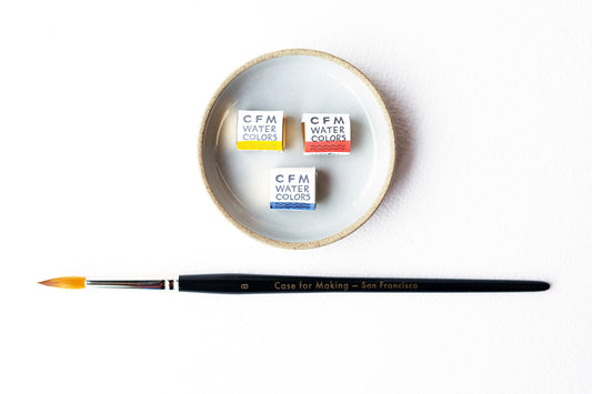 Three Case for Making handmade watercolors in a ceramic Hasami Dish with a Round Size 8 CfM Watercolor brush. With a top down view.