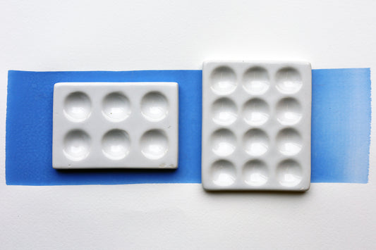 Two White Porcelain spot mixing plates on painted swatch with a white background