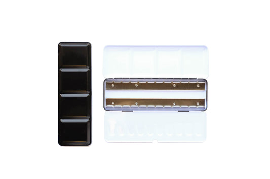 Medium Empty Palette - a closed palette beside an open palette.  The exterior is shiny black and the inside is shiny white with mixing space in the lids.  Interior shows 2 empty metal rows that the pans of watercolor clip securely into.