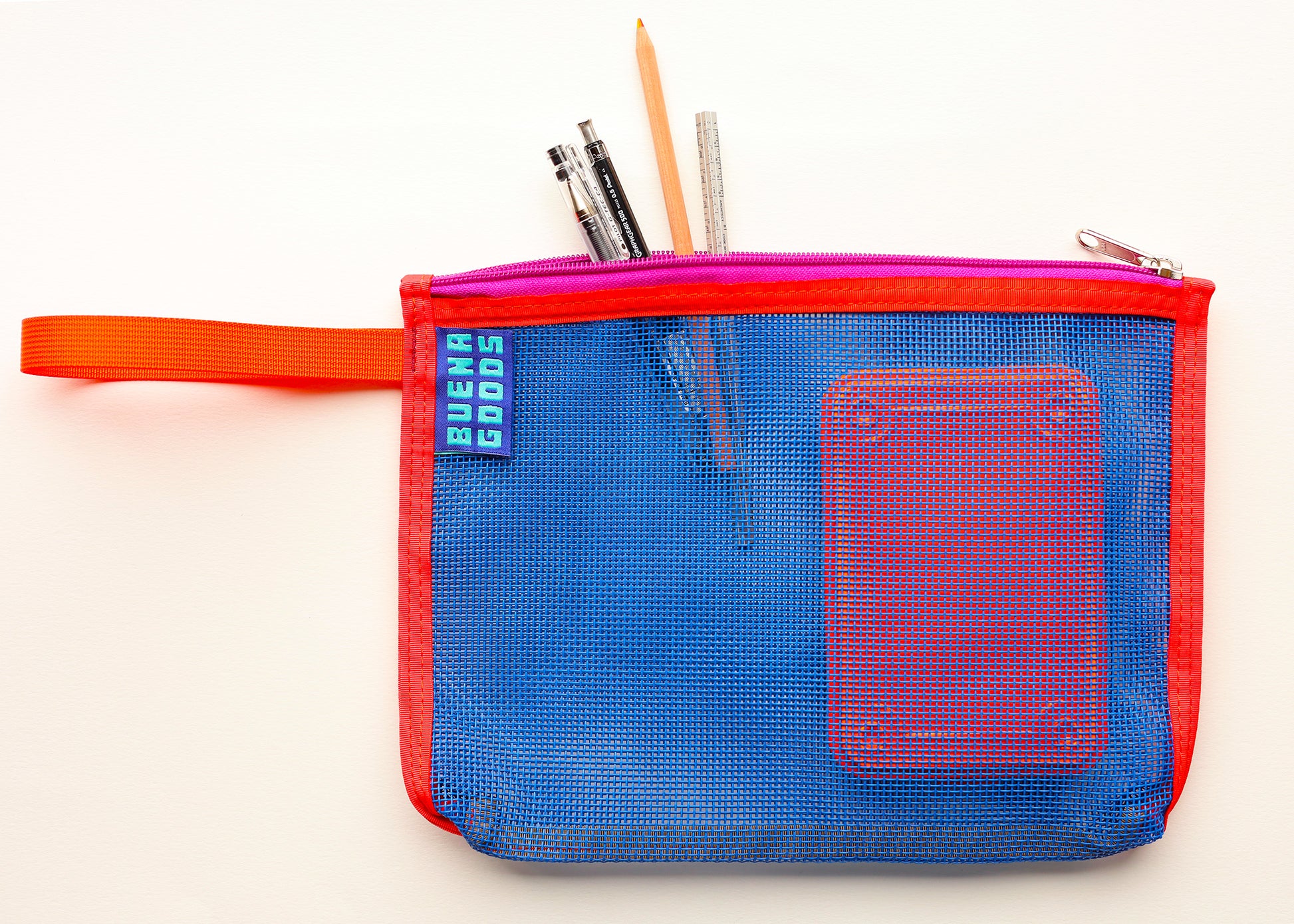 A blue mesh zippered pouch with red trim and a bright orange wrist strap, shown on a white background with pens and a pencil sticking out of the top. A small blue tag on the left reads 'BUENA GOODS'.