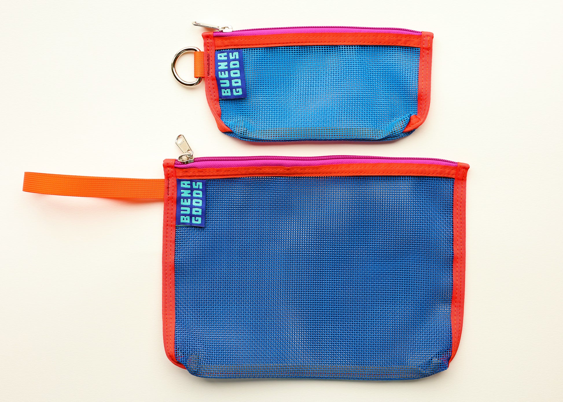 Two mesh zip pouches in blue with red-orange trim and a small metal key ring, shown on a plain white background. One pouch has an orange loop handle, and both have a visible sewn fabric tag reading 'Buena Goods'.