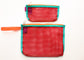 Two mesh zip pouches in red, one small and one medium, with turquoise trim, orange zipper tape, and an orange wrist strap on the larger pouch. Each pouch has a small purple fabric tag with white text that reads 'Buena Goods'.