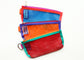 Three mesh bags by buena goods on a white background. The bags are red with green trim, orange with purple trim and blue with red trim. They all have colorful zippers.