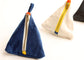 Two triangular fabric pouches with zippered closures on a white background. The front pouch is made of blue denim with a gold zipper, white trim, and a small orange tab.