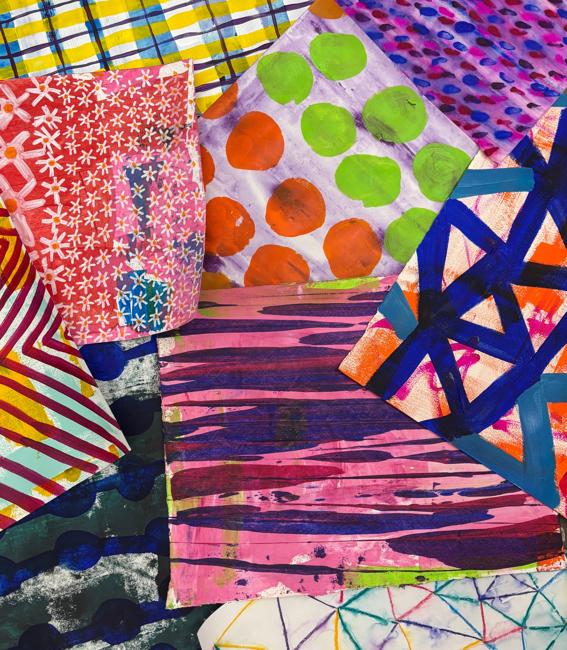 A close-up of a colorful abstract artwork or fabric collage with overlapping geometric and patterned sections in pink, blue, orange, green, yellow, and purple.