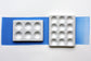 Two White Porcelain spot mixing plates on painted swatch with a white background