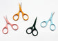 Four pairs of small scissors with colorful handles in orange, pink, dark green, and light blue, arranged on a white background.