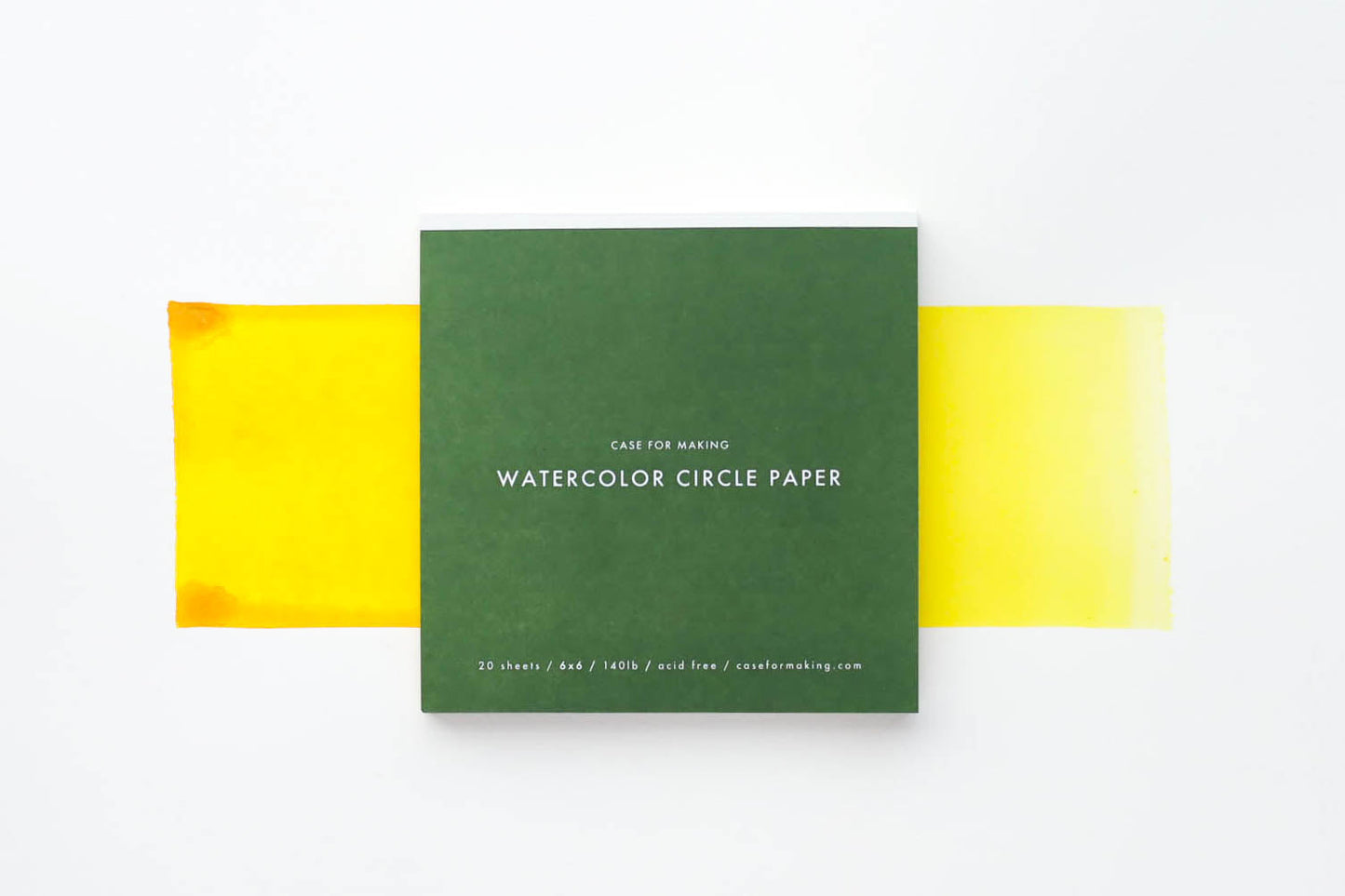 The closed, top-bound 6" x 6" Watercolor Circle Paper pad.  Showing the forest green cover with white lettering. 